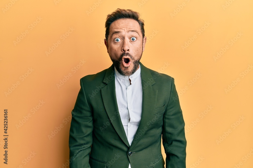 Middle age man wearing business suit afraid and shocked with surprise expression, fear and excited face. Middle age man wearing business suit afraid and shocked with surprise expression, fear and excited face.
