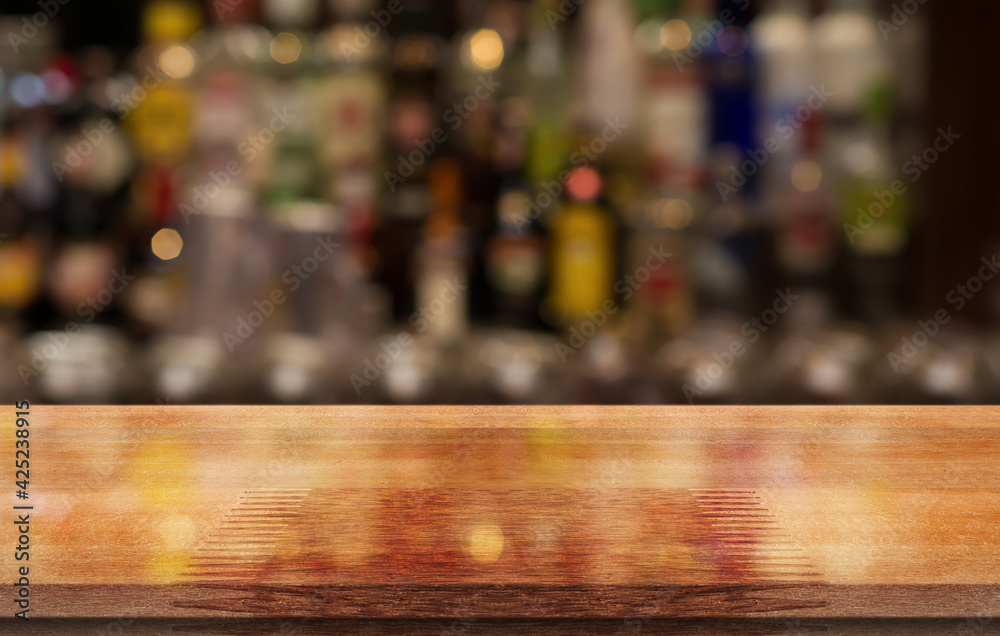 Empty wooden table top with lights bokeh on blur restaurant background.