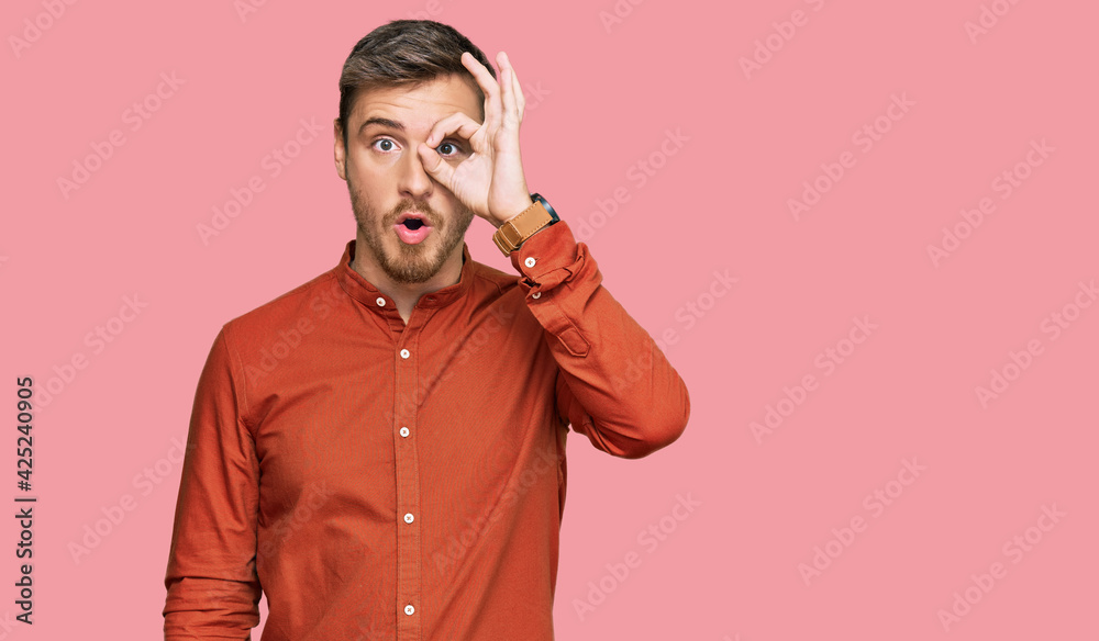 Handsome caucasian man wearing casual clothes doing ok gesture shocked with surprised face, eye looking through fingers. unbelieving expression. Handsome caucasian man wearing casual clothes doing ok gesture shocked with surprised face, eye looking through fingers. unbelieving expression.