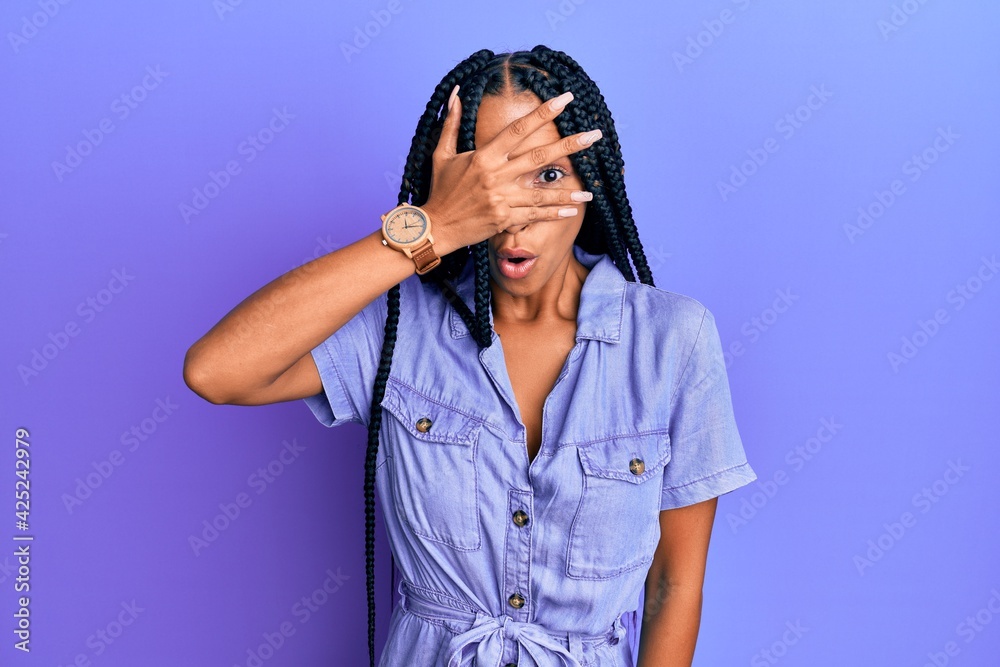 Beautiful hispanic woman wearing casual clothes peeking in shock covering face and eyes with hand, looking through fingers afraid Beautiful hispanic woman wearing casual clothes peeking in shock covering face and eyes with hand, looking through fingers afraid