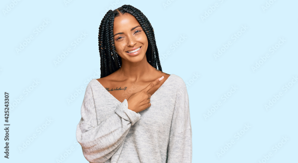 Beautiful hispanic woman wearing casual clothes cheerful with a smile of face pointing with hand and finger up to the side with happy and natural expression on face Beautiful hispanic woman wearing casual clothes cheerful with a smile of face pointing with hand and finger up to the side with happy and natural expression on face