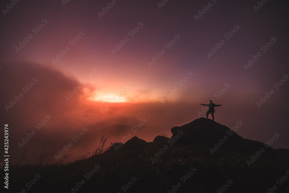 Silhouette of a person above the clouds
