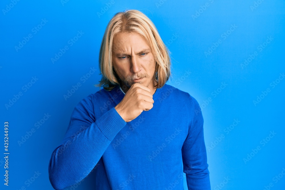 Caucasian young man with long hair wearing casual clothes feeling unwell and coughing as symptom for cold or bronchitis. health care concept. Caucasian young man with long hair wearing casual clothes feeling unwell and coughing as symptom for cold or bronchitis. health care concept.