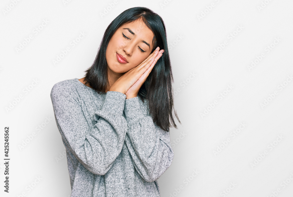 Beautiful asian young woman wearing casual clothes sleeping tired dreaming and posing with hands together while smiling with closed eyes. Beautiful asian young woman wearing casual clothes sleeping tired dreaming and posing with hands together while smiling with closed eyes.