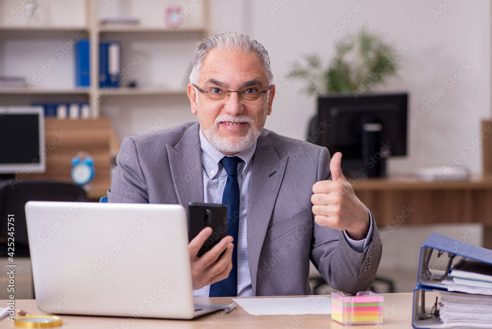 Old male employee working in the office Old male employee working in the office