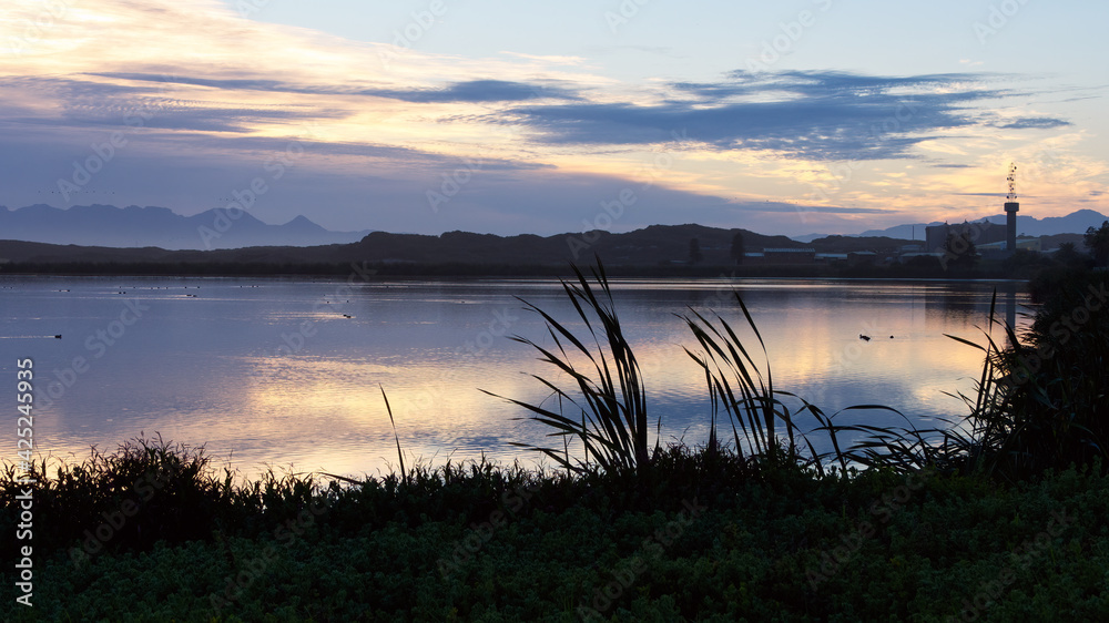 The dawn sky is reflected in a lake in the False Bay Nature Reserve in Cape Town, South Africa.