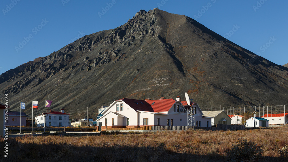 Northern town in the Arctic. Egvekinot, Chukotka, Far North of Russia. On the slope of the mountain, schoolchildren laid out a text made of stones 