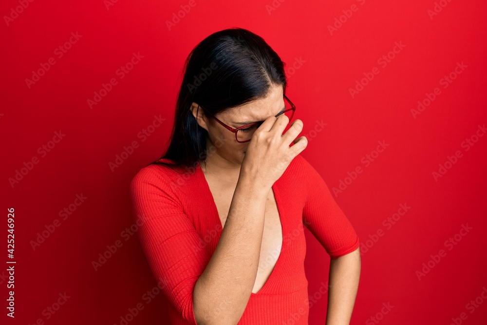 Young latin woman wearing casual clothes and glasses tired rubbing nose and eyes feeling fatigue and headache. stress and frustration concept. Young latin woman wearing casual clothes and glasses tired rubbing nose and eyes feeling fatigue and headache. stress and frustration concept.