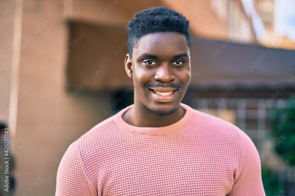 Young african american man smiling happy standing at the city. Young african american man smiling happy standing at the city.