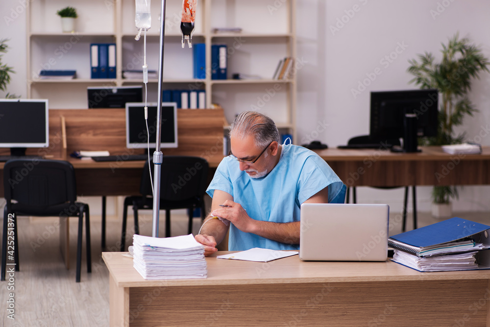 Old male employee in blood transfusion concept Old male employee in blood transfusion concept