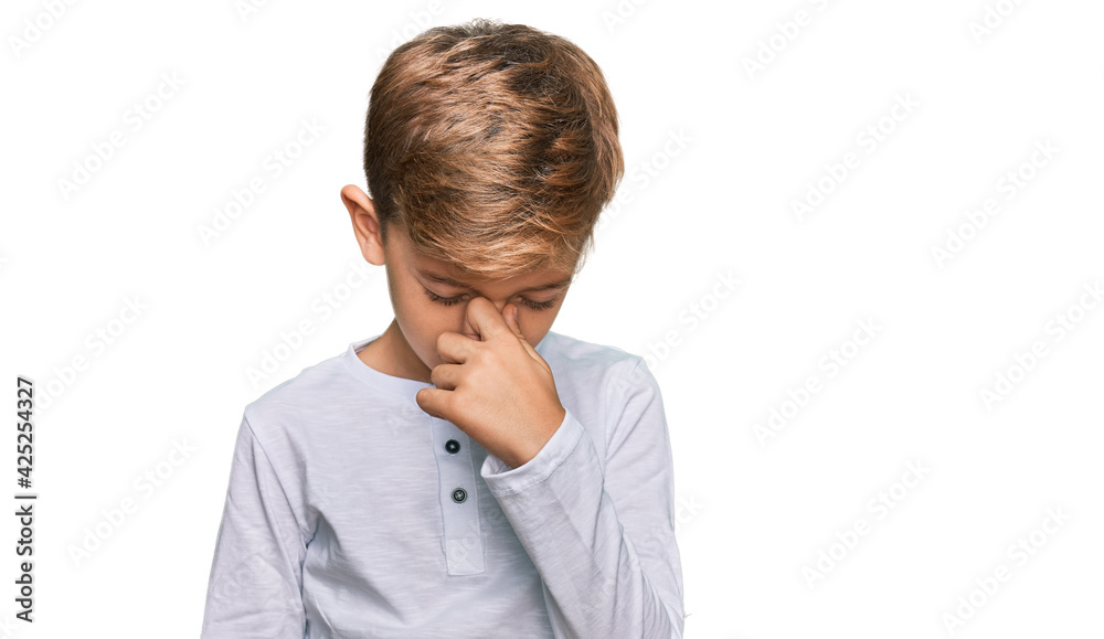 Little caucasian boy kid wearing casual clothes tired rubbing nose and eyes feeling fatigue and headache. stress and frustration concept. Little caucasian boy kid wearing casual clothes tired rubbing nose and eyes feeling fatigue and headache. stress and frustration concept.