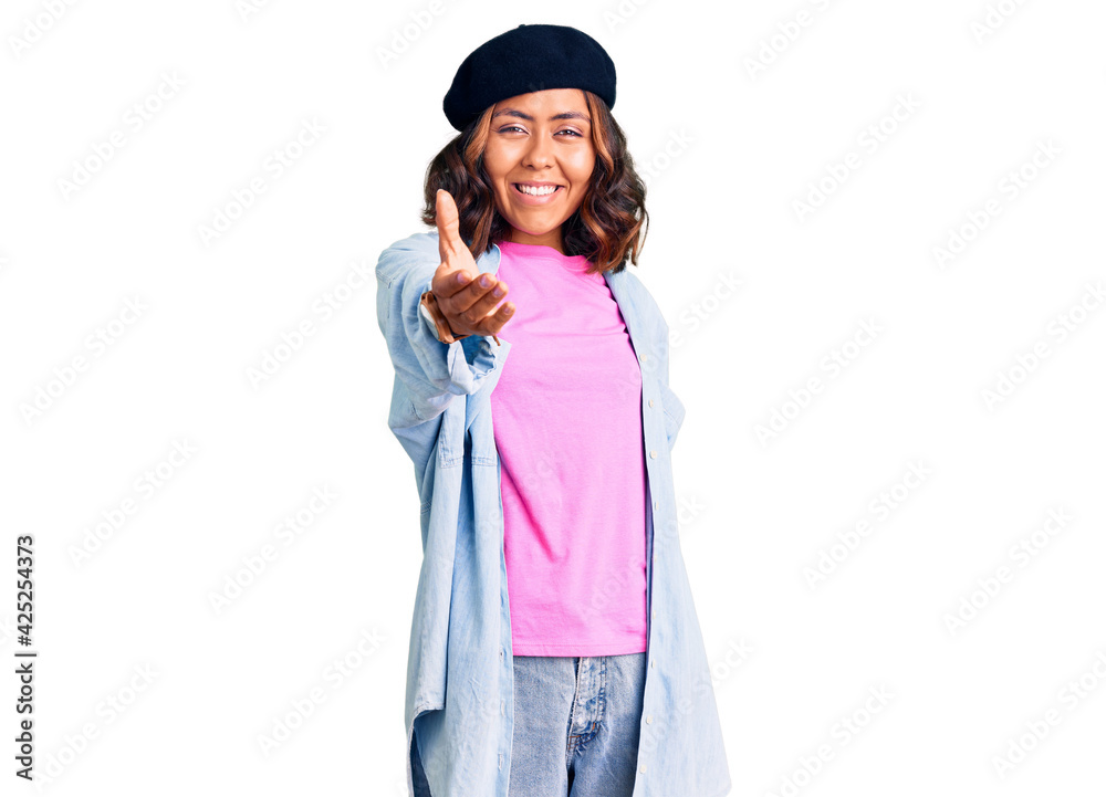 Young beautiful mixed race woman wearing french look with beret smiling friendly offering handshake as greeting and welcoming. successful business. Young beautiful mixed race woman wearing french look with beret smiling friendly offering handshake as greeting and welcoming. successful business.