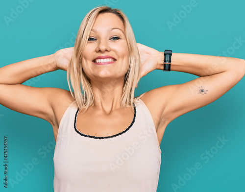 Middle age caucasian woman wearing casual clothes relaxing and stretching, arms and hands behind head and neck smiling happy © Krakenimages.com