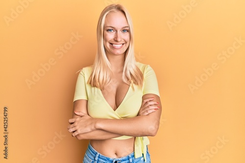 Young blonde girl wearing casual clothes happy face smiling with crossed arms looking at the camera. positive person. © Krakenimages.com