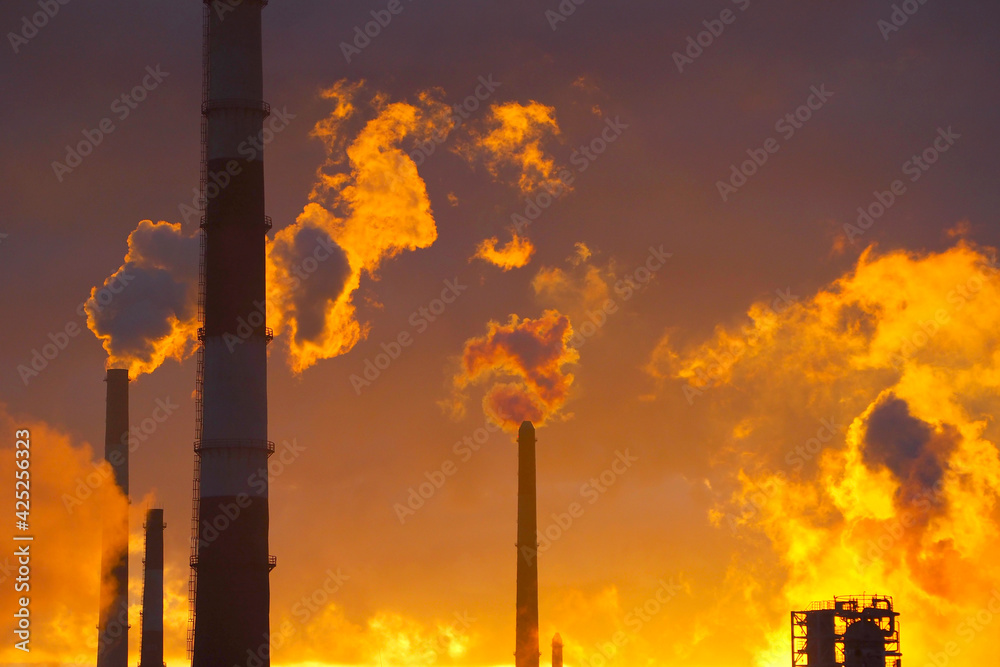 Φωτογραφία Environmental pollution. Factory pipes. Sunset background