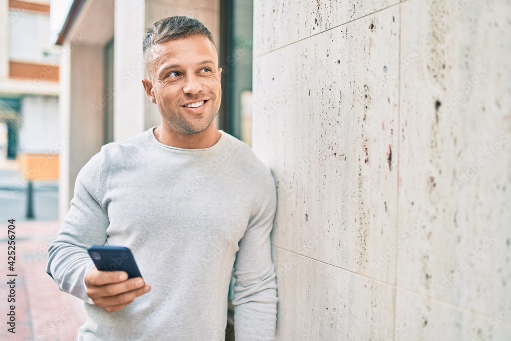 Obraz premium Young caucasian man smiling happy using smartphone at the city.