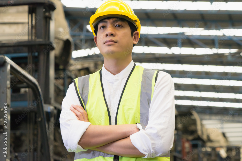 Smart one Asian engineer workers stand and crossed arms in factory-warehouse Smart one Asian engineer workers stand and crossed arms in factory-warehouse
