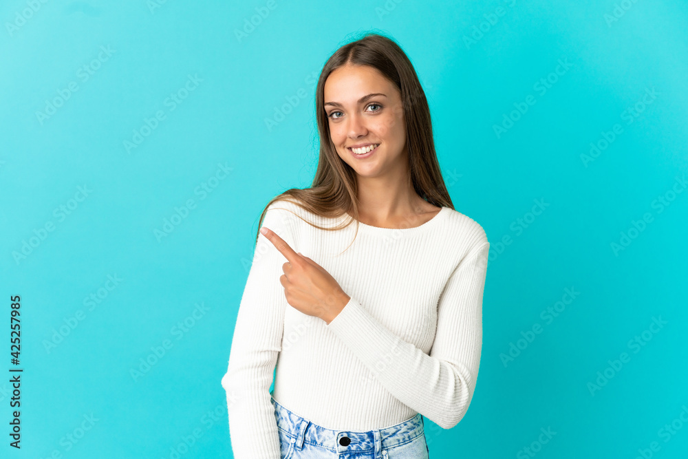 Young woman over isolated blue background pointing to the side to present a product Young woman over isolated blue background pointing to the side to present a product