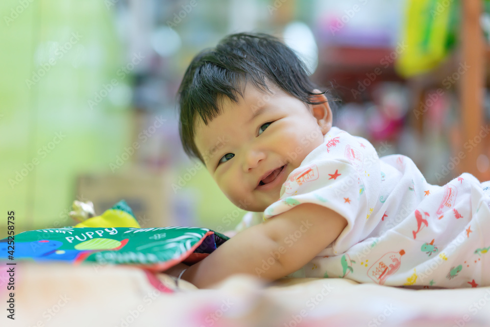 Asian Happy baby crawling and playing with educational toys on the bed. Cute baby smiling and playing toy use as baby development and education concept. Asian Happy baby crawling and playing with educational toys on the bed. Cute baby smiling and playing toy use as baby development and education concept.