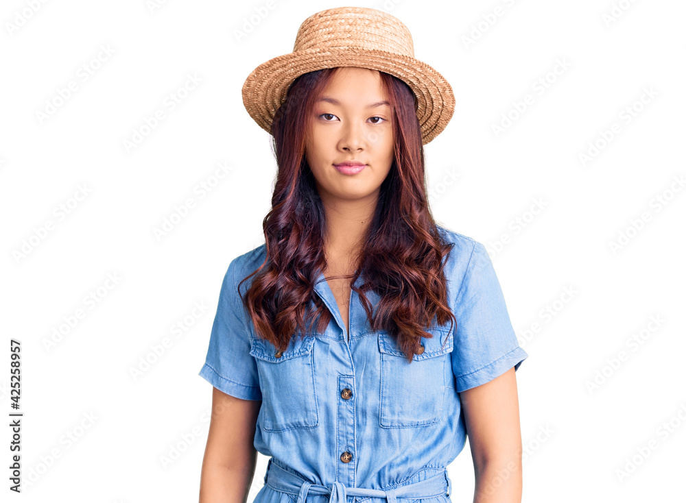 Young beautiful chinese girl wearing summer hat looking sleepy and tired, exhausted for fatigue and hangover, lazy eyes in the morning. Young beautiful chinese girl wearing summer hat looking sleepy and tired, exhausted for fatigue and hangover, lazy eyes in the morning.