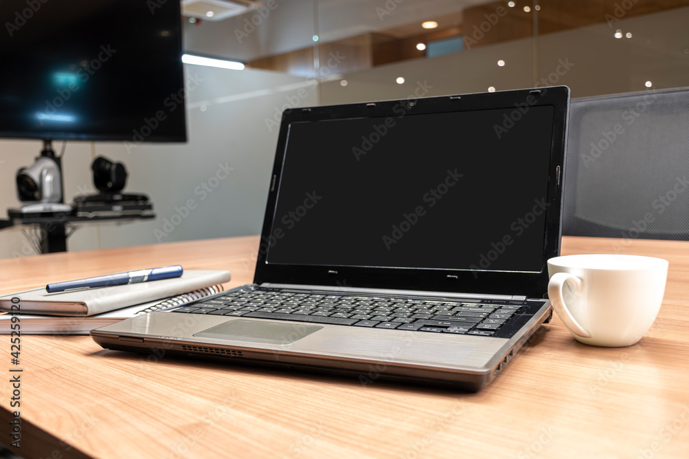 Laptop display blank on table in meeting room. Laptop display blank on table in meeting room.