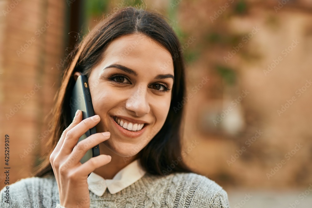 Young hispanic woman smiling happy talking on the smartphone at the city. Young hispanic woman smiling happy talking on the smartphone at the city.