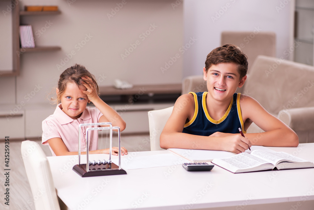 Fototapeta premium Schoolboy and his small sister staying at home during pandemic