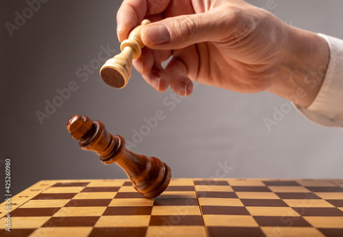 Business strategy concept. Knight making final last step to make checkmate in chess, falling king photo