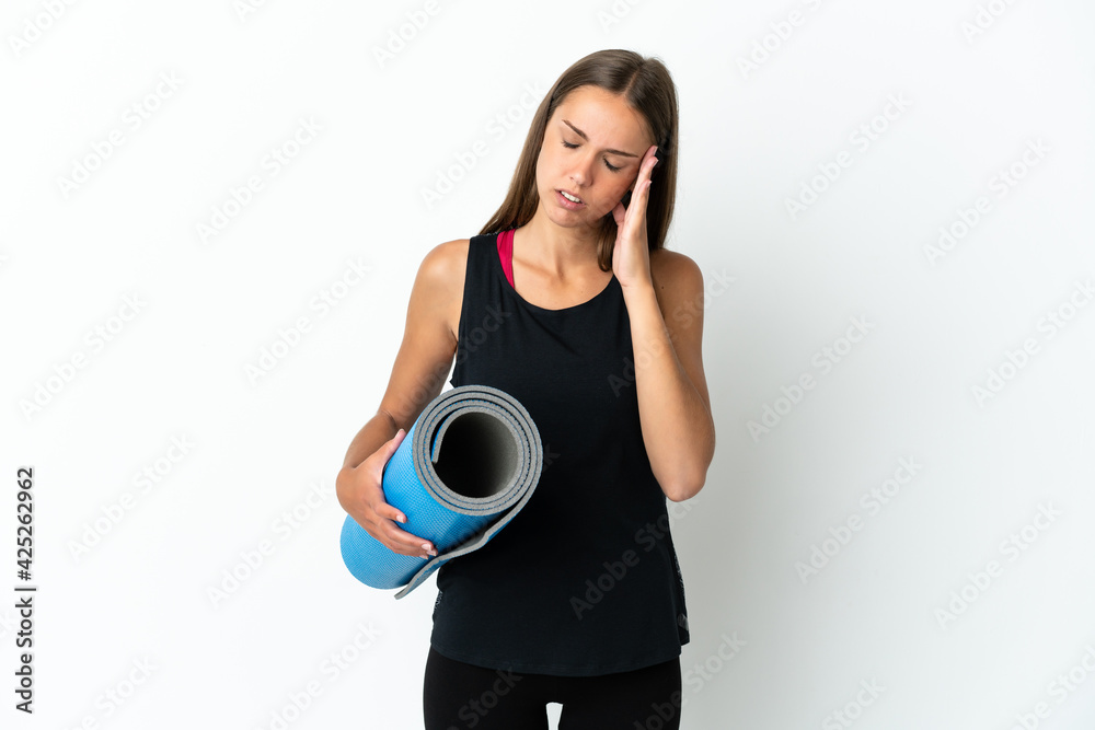 Sport woman going to yoga classes while holding a mat over isolated white background with headache Sport woman going to yoga classes while holding a mat over isolated white background with headache