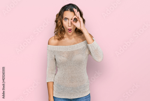 Beautiful young caucasian woman wearing casual clothes doing ok gesture shocked with surprised face, eye looking through fingers. unbelieving expression. © Krakenimages.com