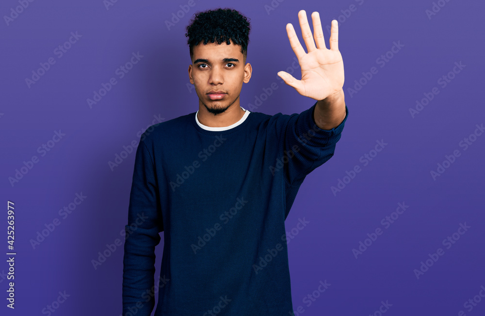 Young african american man wearing casual clothes doing stop sing with palm of the hand. warning expression with negative and serious gesture on the face. Young african american man wearing casual clothes doing stop sing with palm of the hand. warning expression with negative and serious gesture on the face.