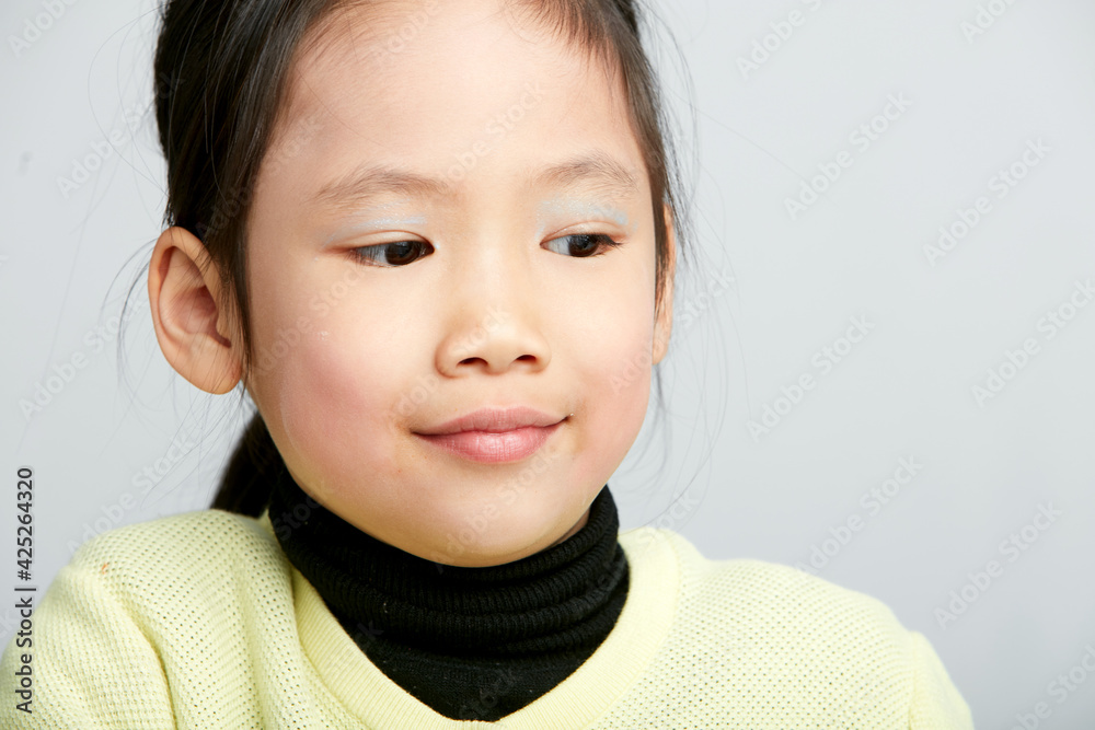 Asian little girl doing makeup on herself in fun Asian little girl doing makeup on herself in fun