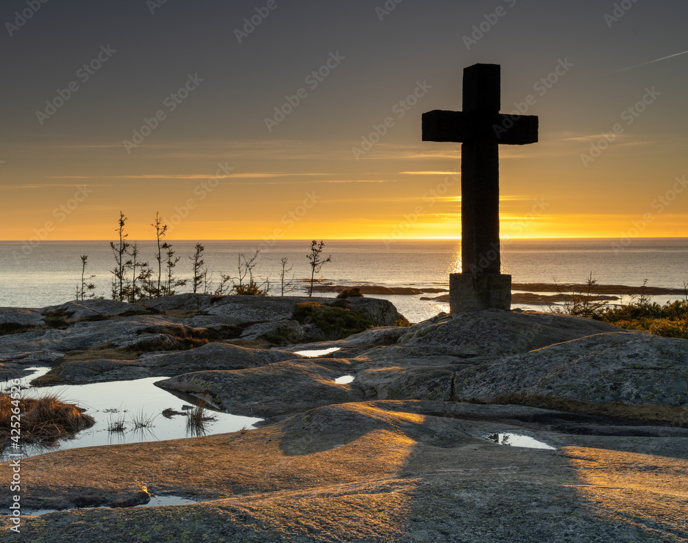 Catholic cross towering over the fjord