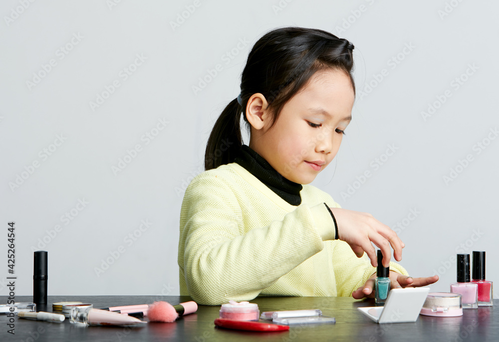 Asian little girl doing makeup on herself in fun Asian little girl doing makeup on herself in fun