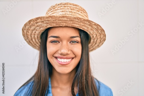 Young latin tourist girl on vacation smiling happy walking at the city.