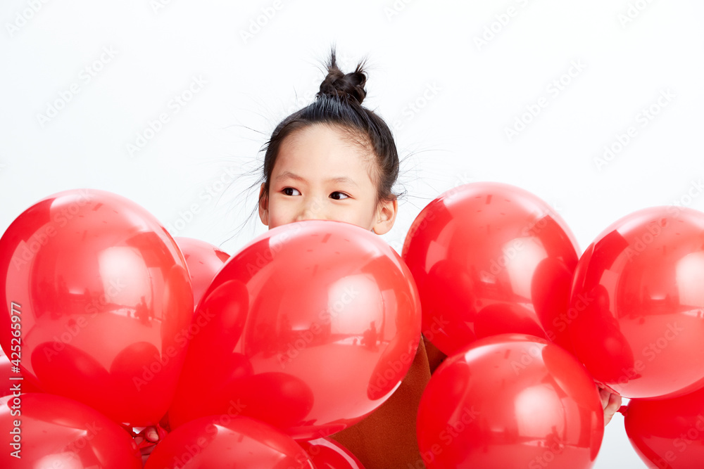 Cute Asian little girl playing with festive red balloons. Wearing traditional Chinese New Year costumes Cute Asian little girl playing with festive red balloons. Wearing traditional Chinese New Year costumes