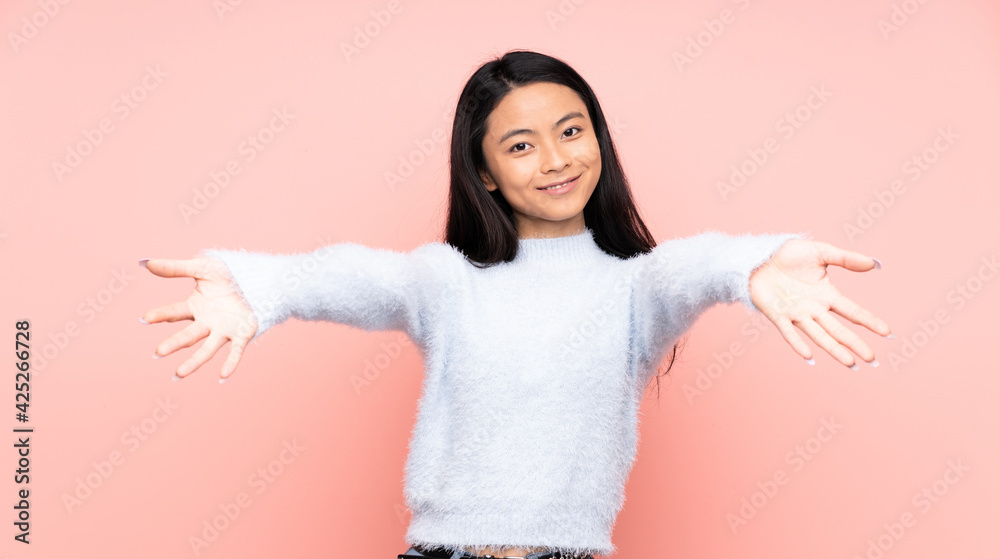 Teenager Chinese woman isolated on pink background presenting and inviting to come with hand Teenager Chinese woman isolated on pink background presenting and inviting to come with hand