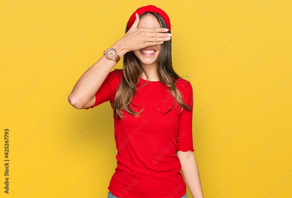 Young brunette woman wearing casual clothes smiling and laughing with hand on face covering eyes for surprise. blind concept. Young brunette woman wearing casual clothes smiling and laughing with hand on face covering eyes for surprise. blind concept.