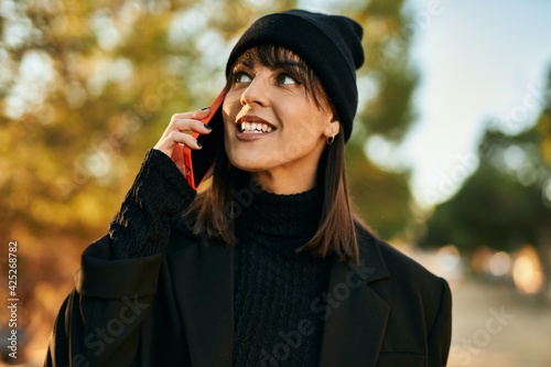 Young hispanic woman smiling happy talking on the smartphone at the park. © Krakenimages.com