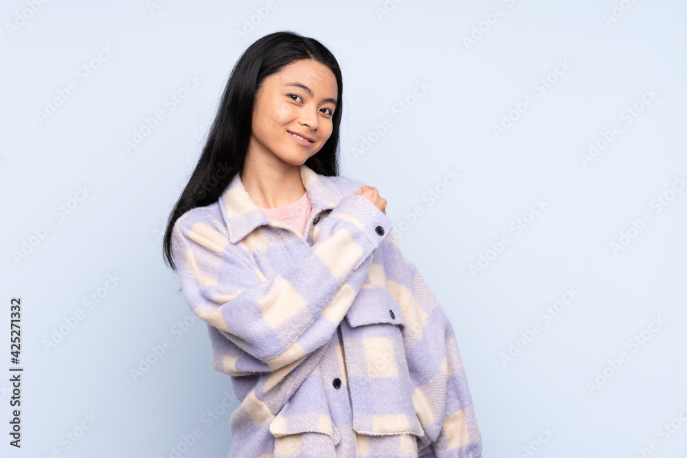 Teenager Chinese woman isolated on blue background celebrating a victory Teenager Chinese woman isolated on blue background celebrating a victory