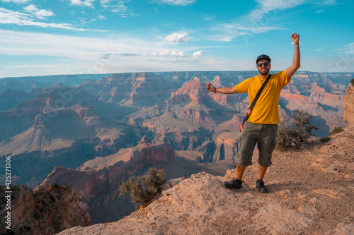 A boy in a yellow shirt enjoying the sunset views at Mojave Point in Grand Canyon. Arizona.