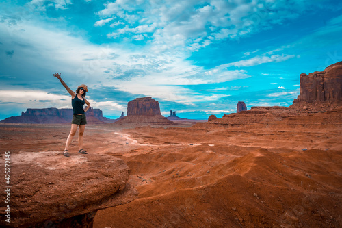 A young woman in a black T-shirt at John Ford's Point looking at the Monument Valley. Utah.