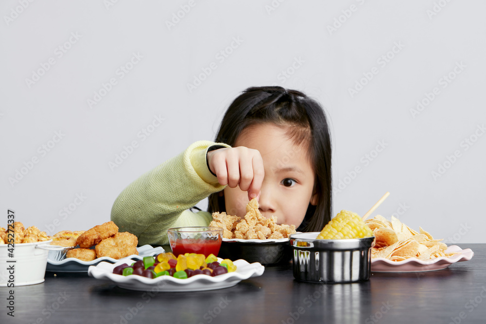 Cute Asian little girl eating happily Cute Asian little girl eating happily