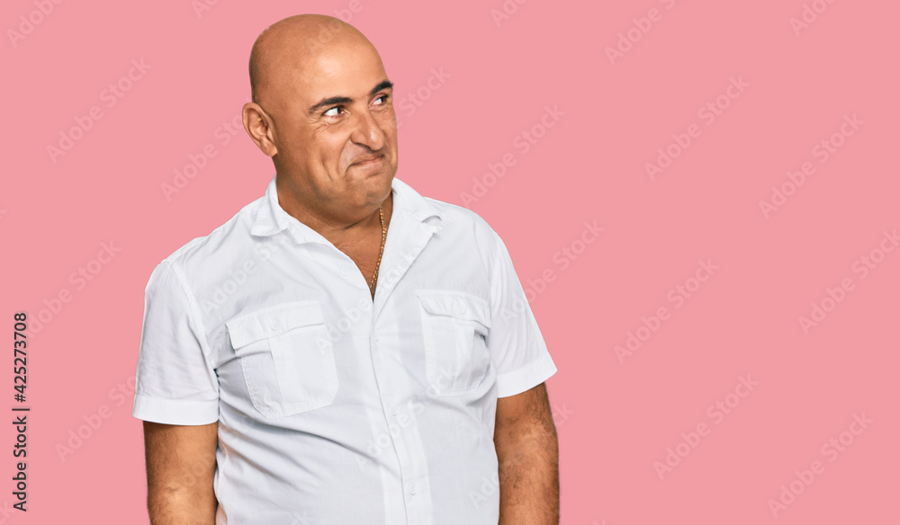 Mature middle east man with mustache wearing casual white shirt smiling looking to the side and staring away thinking. Mature middle east man with mustache wearing casual white shirt smiling looking to the side and staring away thinking.