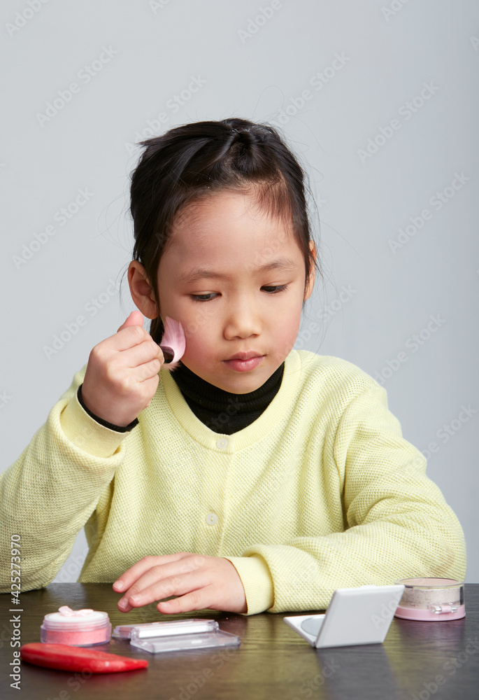 Cute Asian little girl playing in funny makeup Cute Asian little girl playing in funny makeup