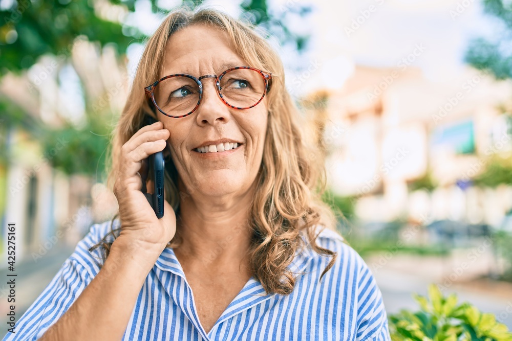 Middle age caucasian woman smiling happy talking on the smartphone at the city. Middle age caucasian woman smiling happy talking on the smartphone at the city.