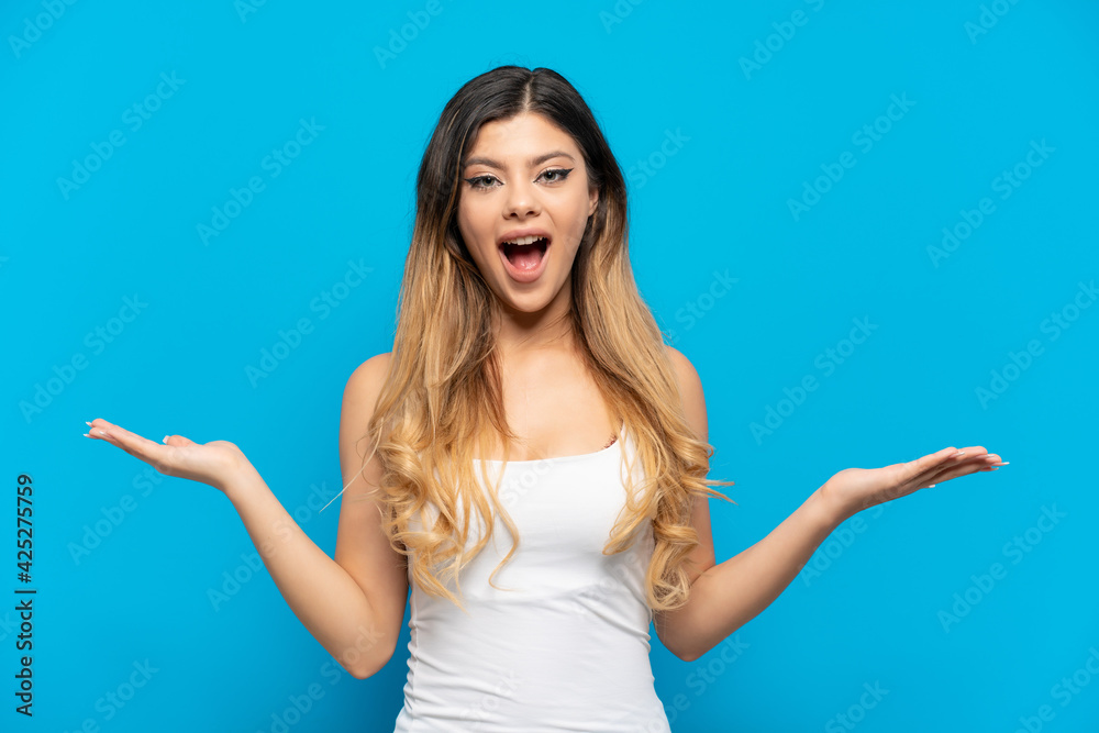 Young Russian girl isolated on blue background with shocked facial expression Young Russian girl isolated on blue background with shocked facial expression