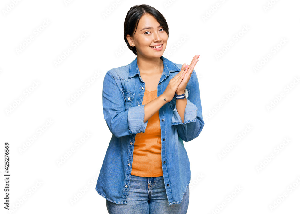 Young beautiful hispanic woman with short hair wearing casual denim jacket clapping and applauding happy and joyful, smiling proud hands together Young beautiful hispanic woman with short hair wearing casual denim jacket clapping and applauding happy and joyful, smiling proud hands together