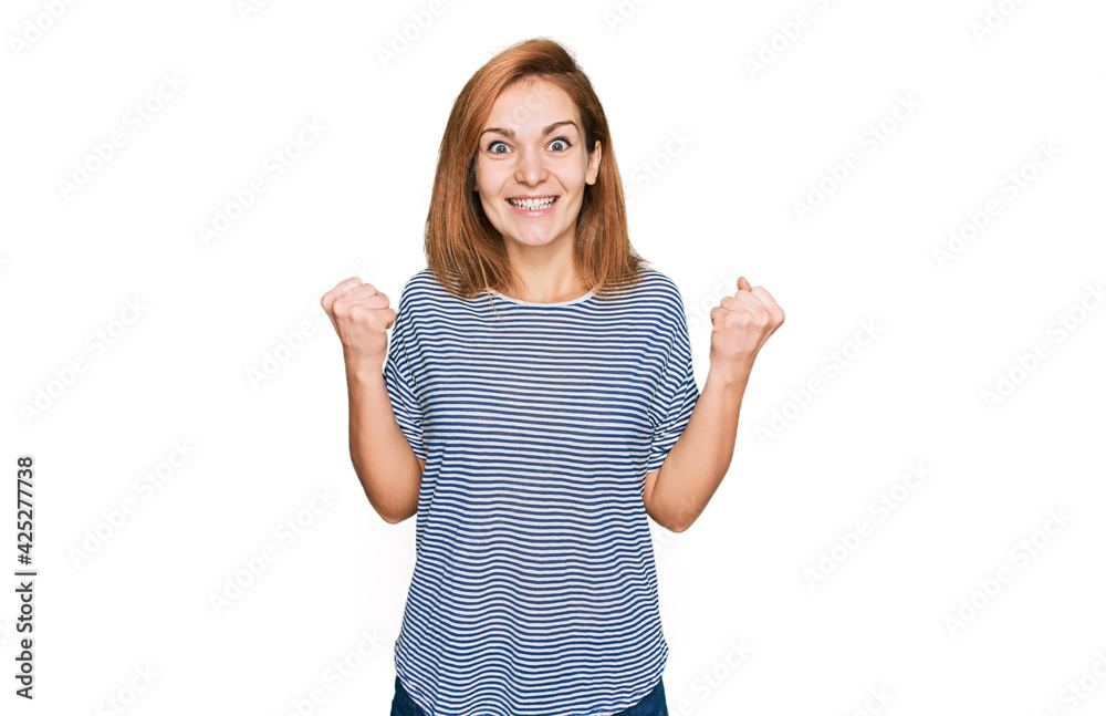 Young caucasian woman wearing casual clothes celebrating surprised and amazed for success with arms raised and open eyes. winner concept. Young caucasian woman wearing casual clothes celebrating surprised and amazed for success with arms raised and open eyes. winner concept.