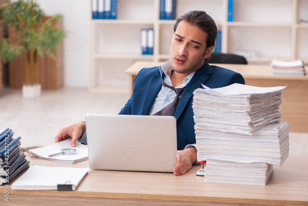 Young male employee unhappy with excessive work Young male employee unhappy with excessive work